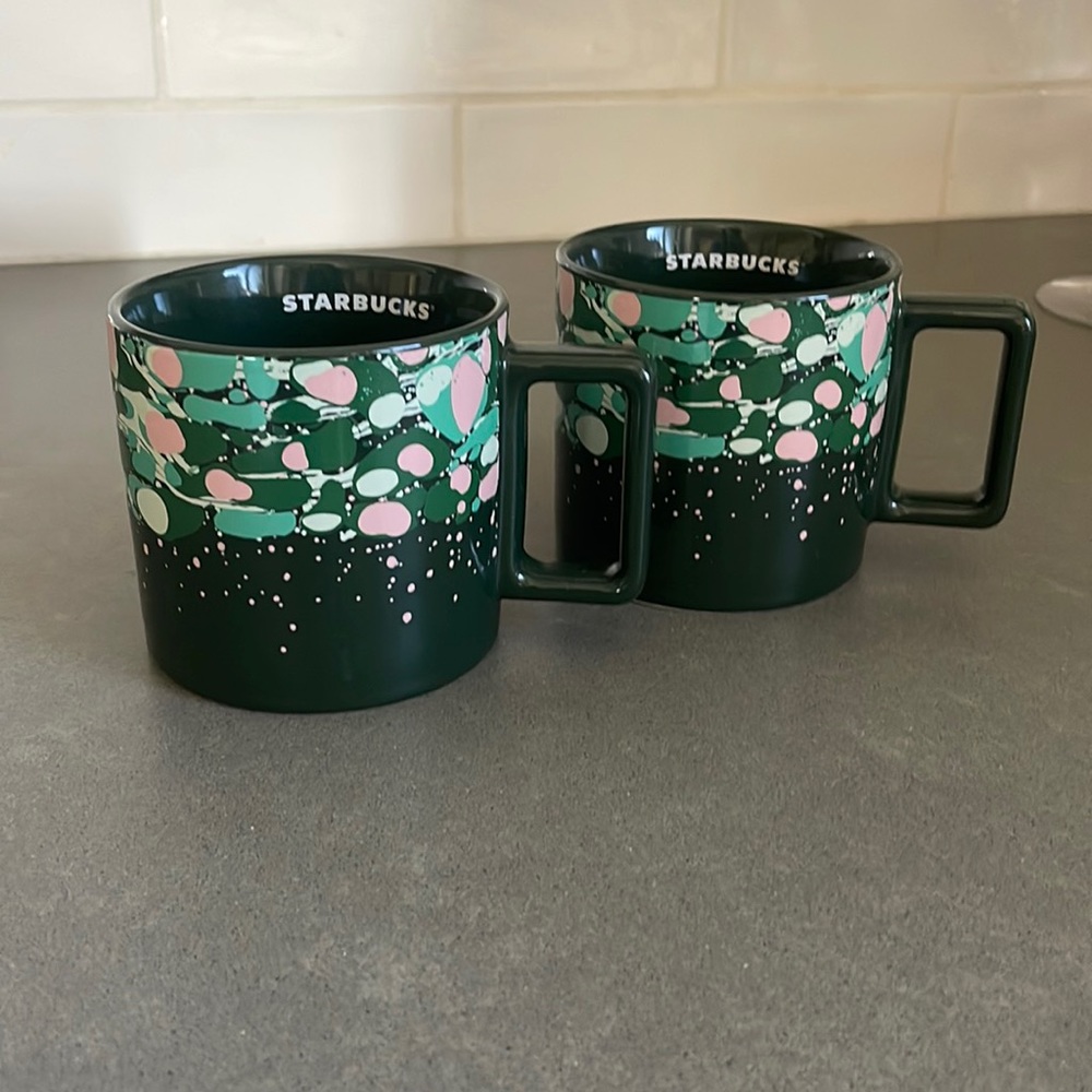 Starbucks coffee cups, 2 dark green, with splashes of pink and greens